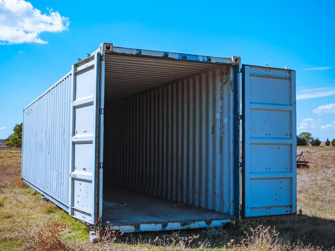 40ft shipping container with its doors open, sitting in an open yard — representative of the units Conway sources to order